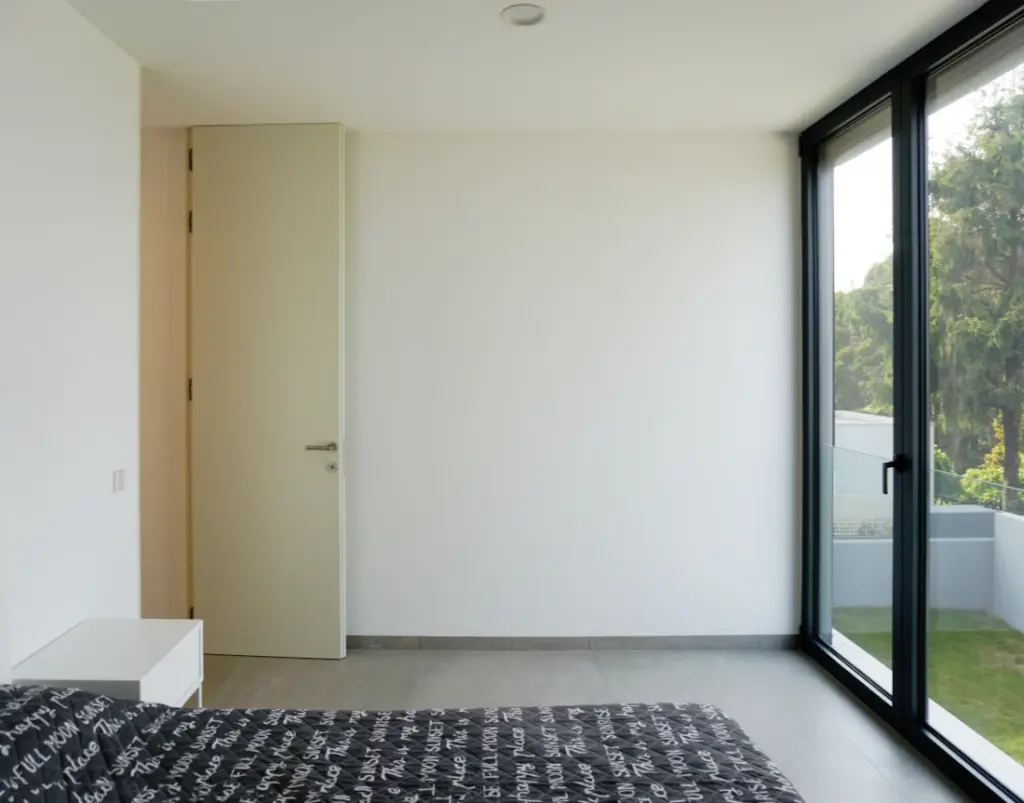 Quarto com janela do chão ao teto que permite enorme iluminação solar e ventilação natural